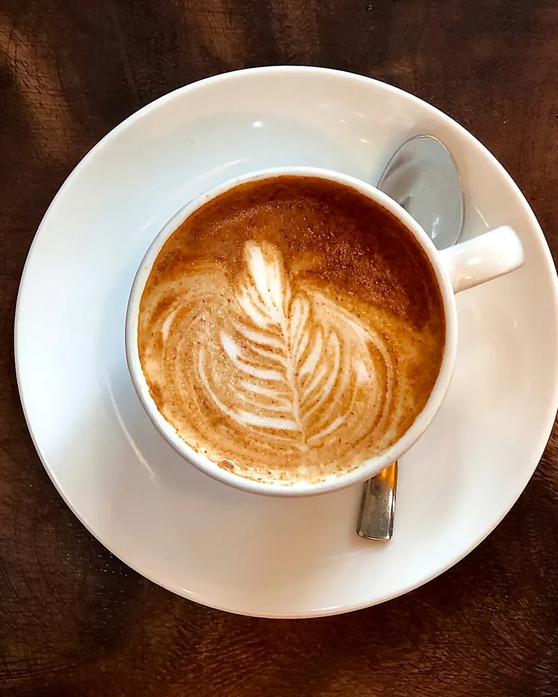 Un latte avec un dessin de feuille, vu de dessus
