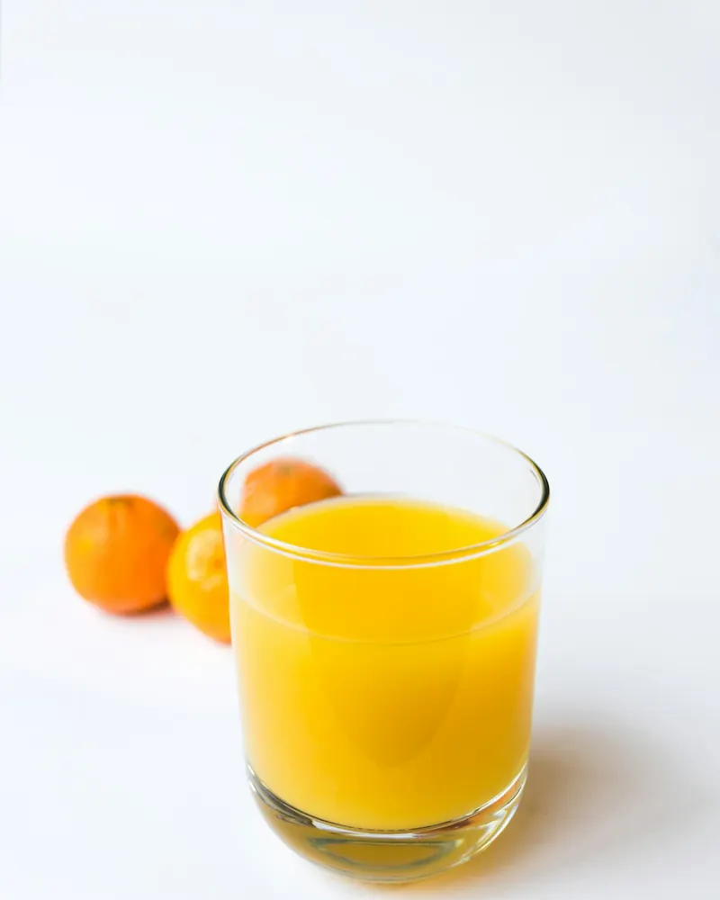 Un verre de jus d'orange et des oranges