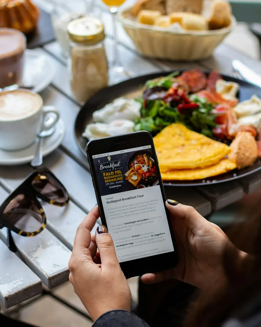 Un téléphone affiche un menu en ligne sur une table de café